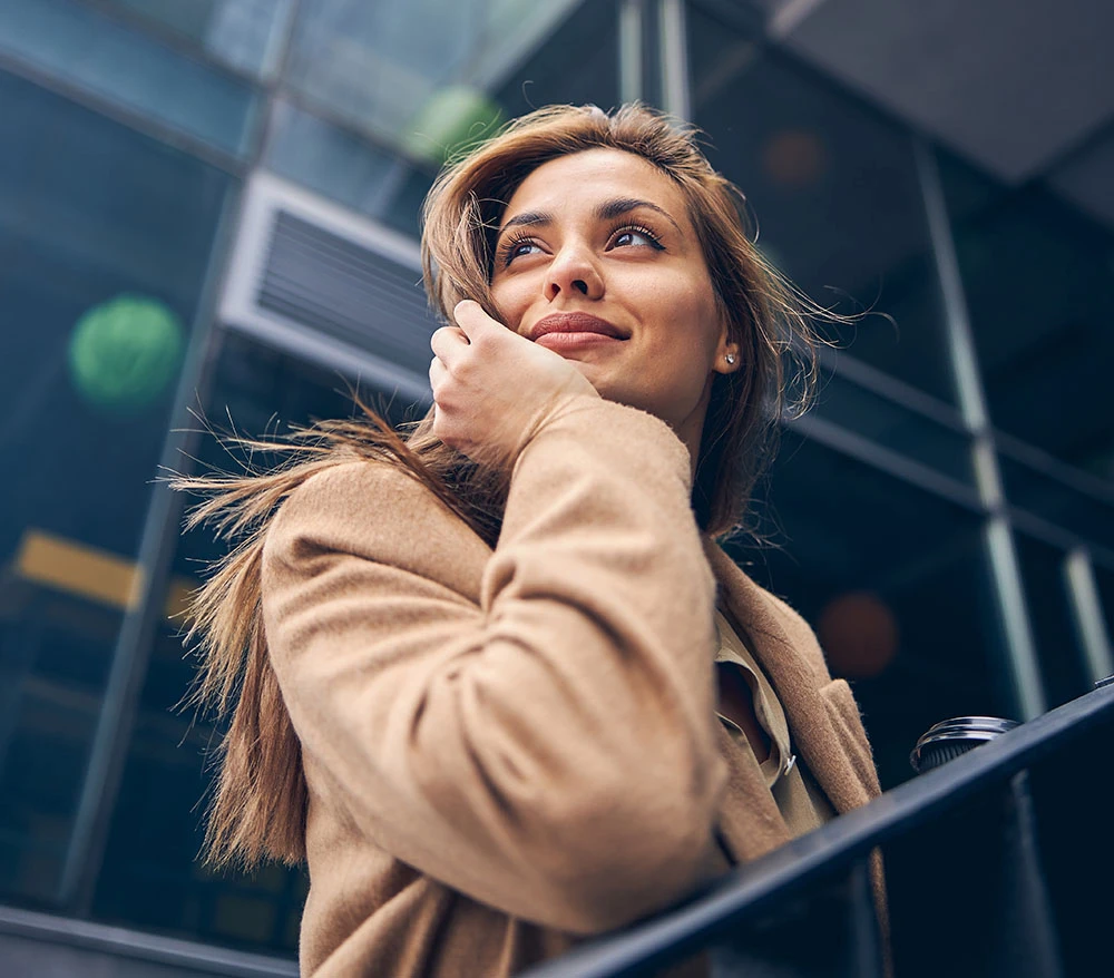 woman leaning on railing looking out | Raggio Facial Plastic Surgery